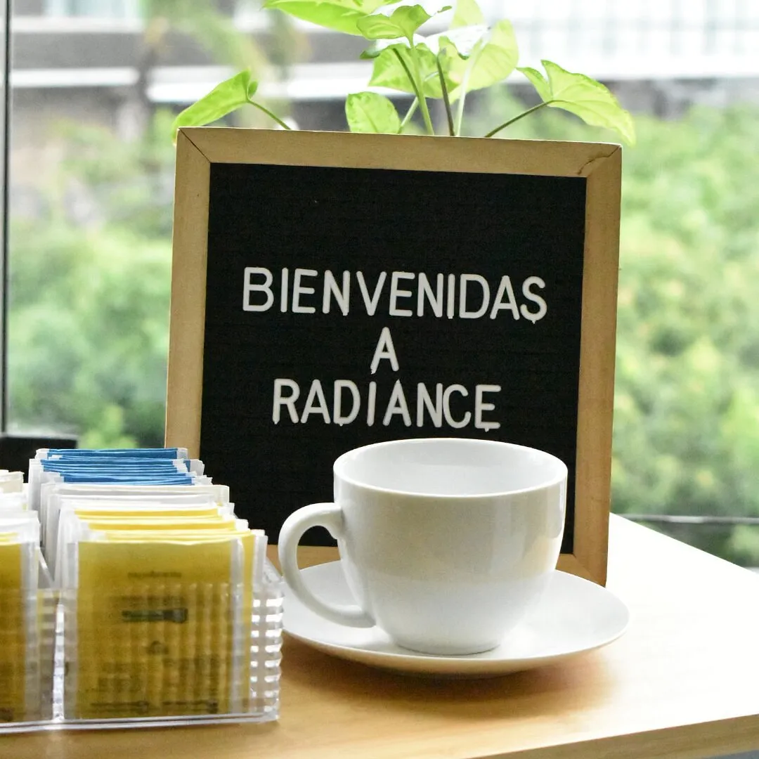 Cartel «Bienvenidas a Radiance» junto a una taza de té