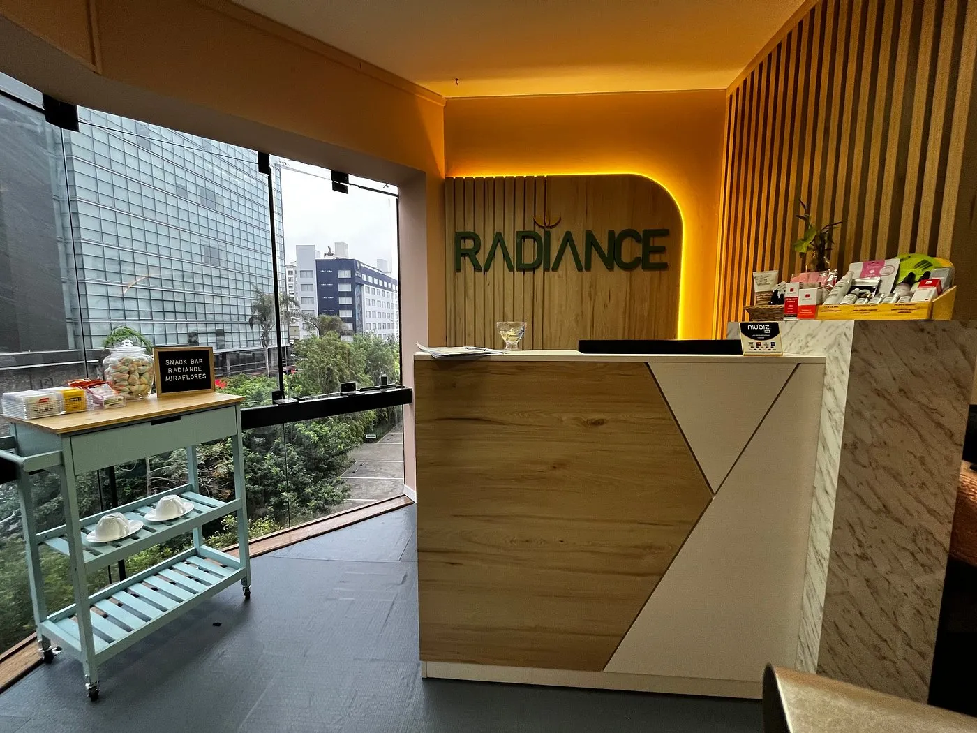 Recepción de Radiance Miraflores, con el logo en el muro de madera